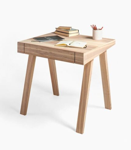 A wooden table with books and pencils on top of it.