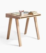 A wooden table with books and pencils on top of it.