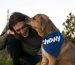 A man and his dog are kissing each other.